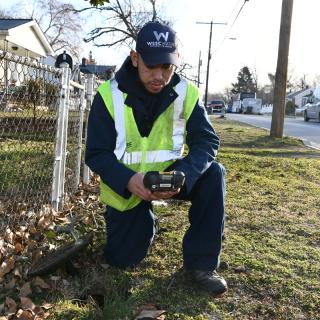 WSSC Water meter readers wear branded uniforms and safety vests, all displaying the WSSC Water logo. They also carry badges that anyone can ask to review. 